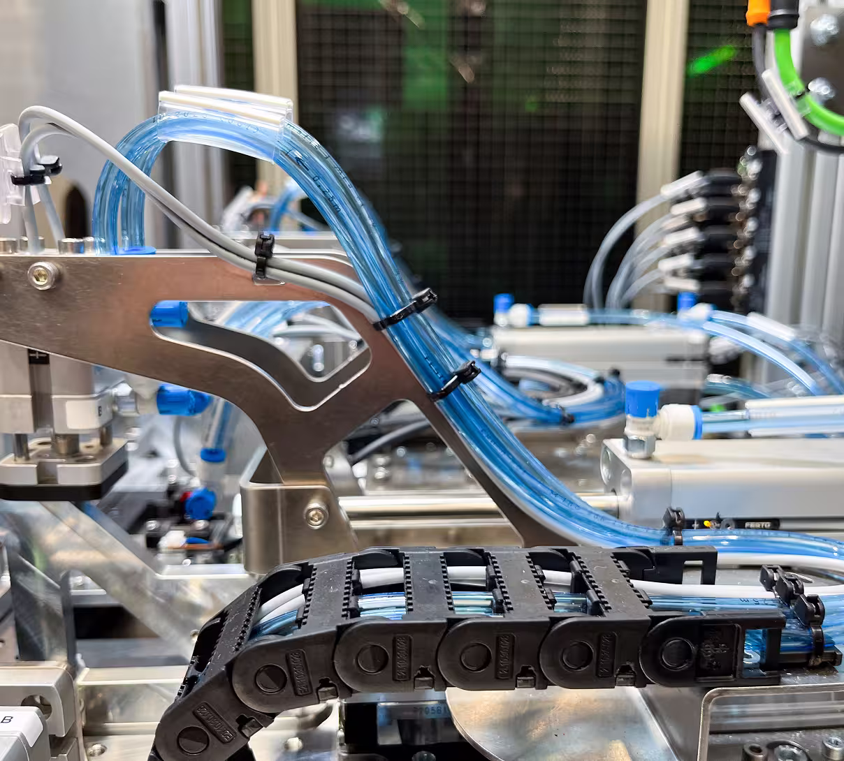 Close-up of blue translucent tubes and cables organized on industrial machinery components.