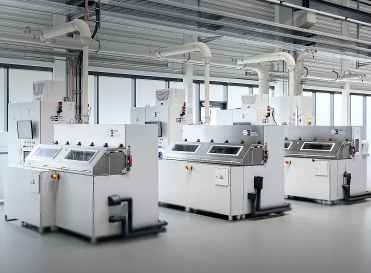 Three oil pump test stands with integrated control panels in a clean industrial testing facility.