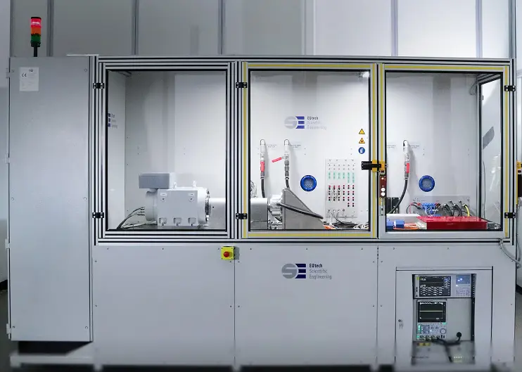 Large white industrial testbench with glass panels and electronic controls inside.