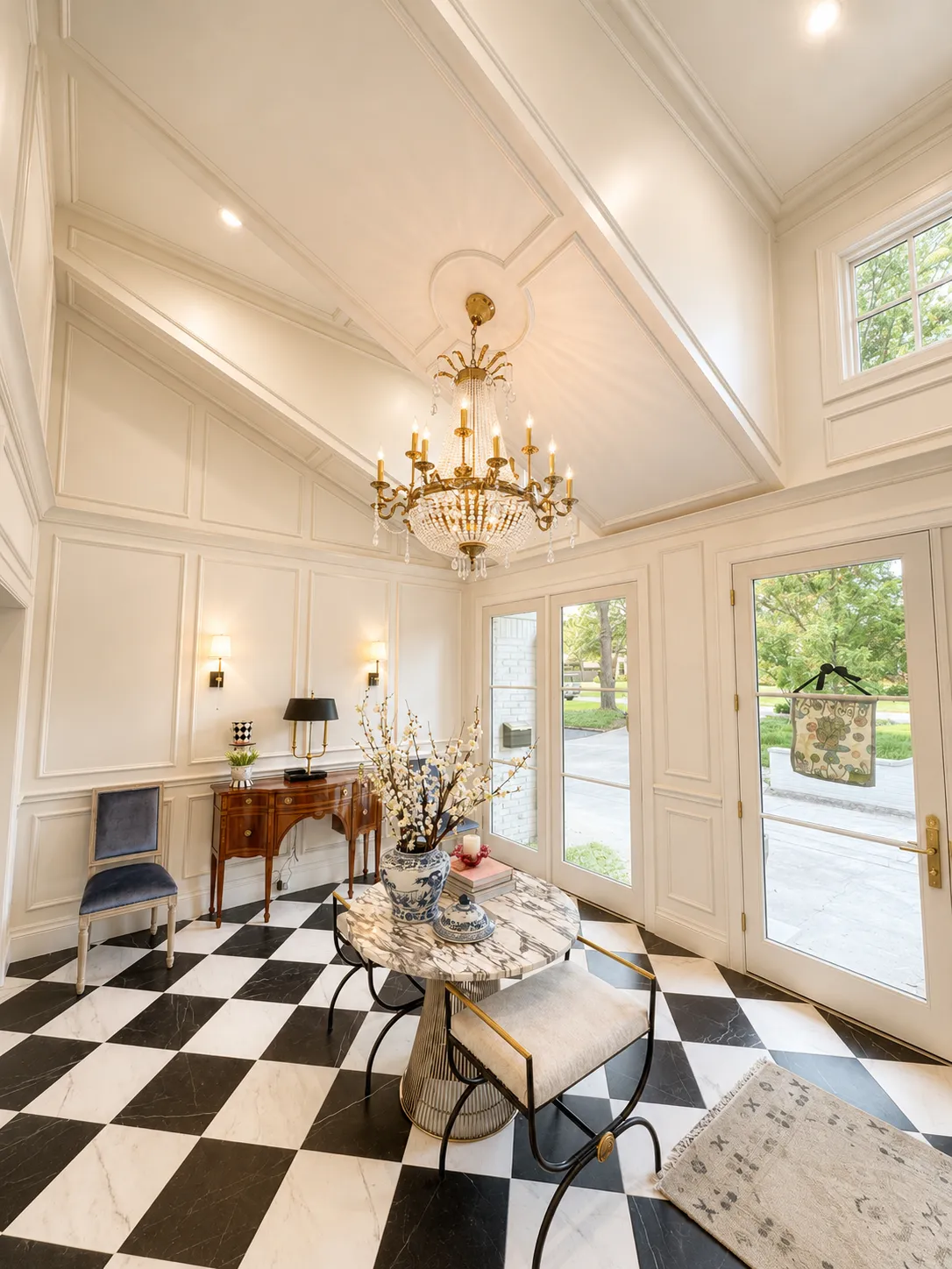 Completed whole-home renovation entry with paneled walls and chandelier