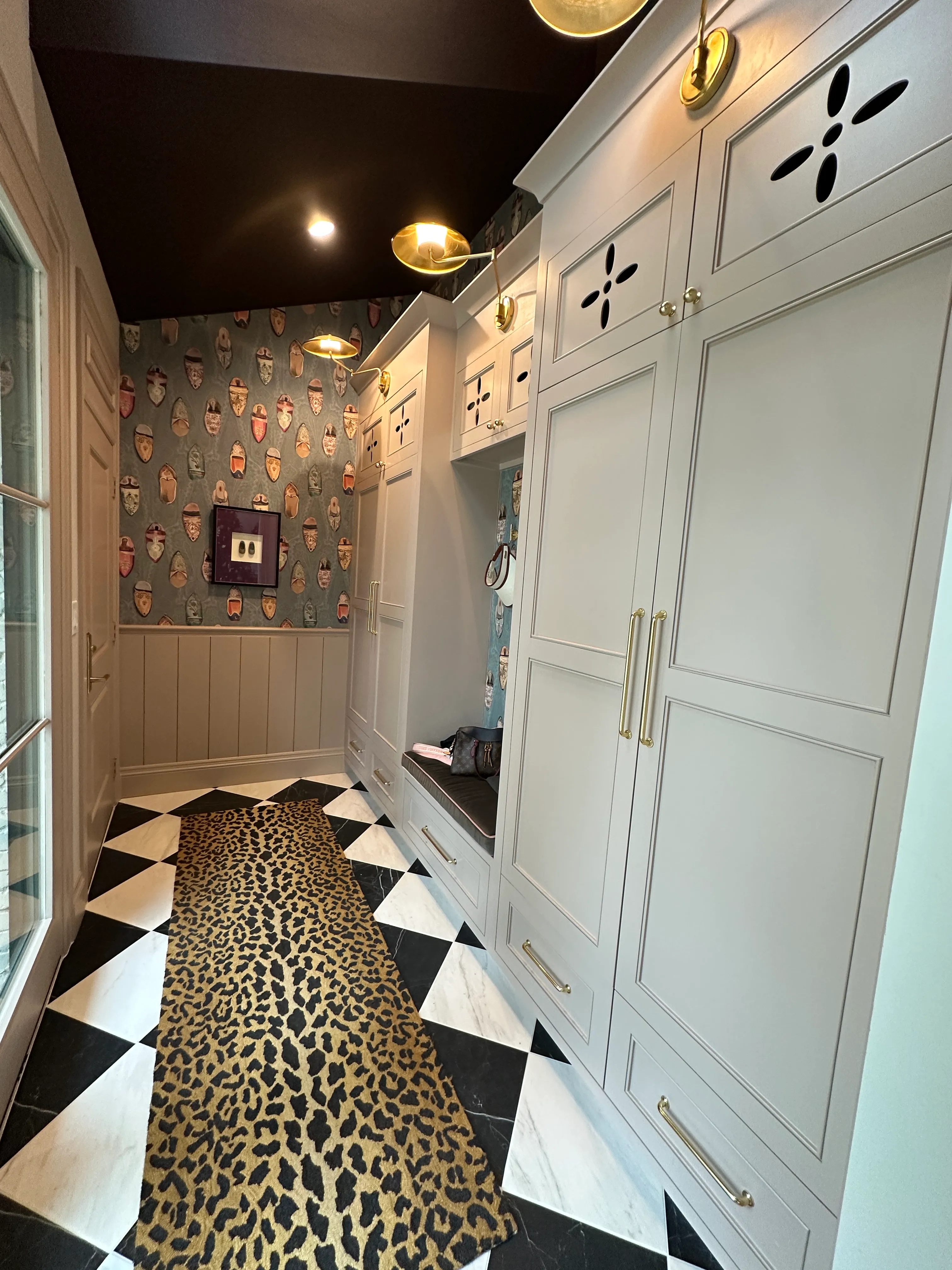 Custom cabinetry and wallpapered powder room with leopard runner