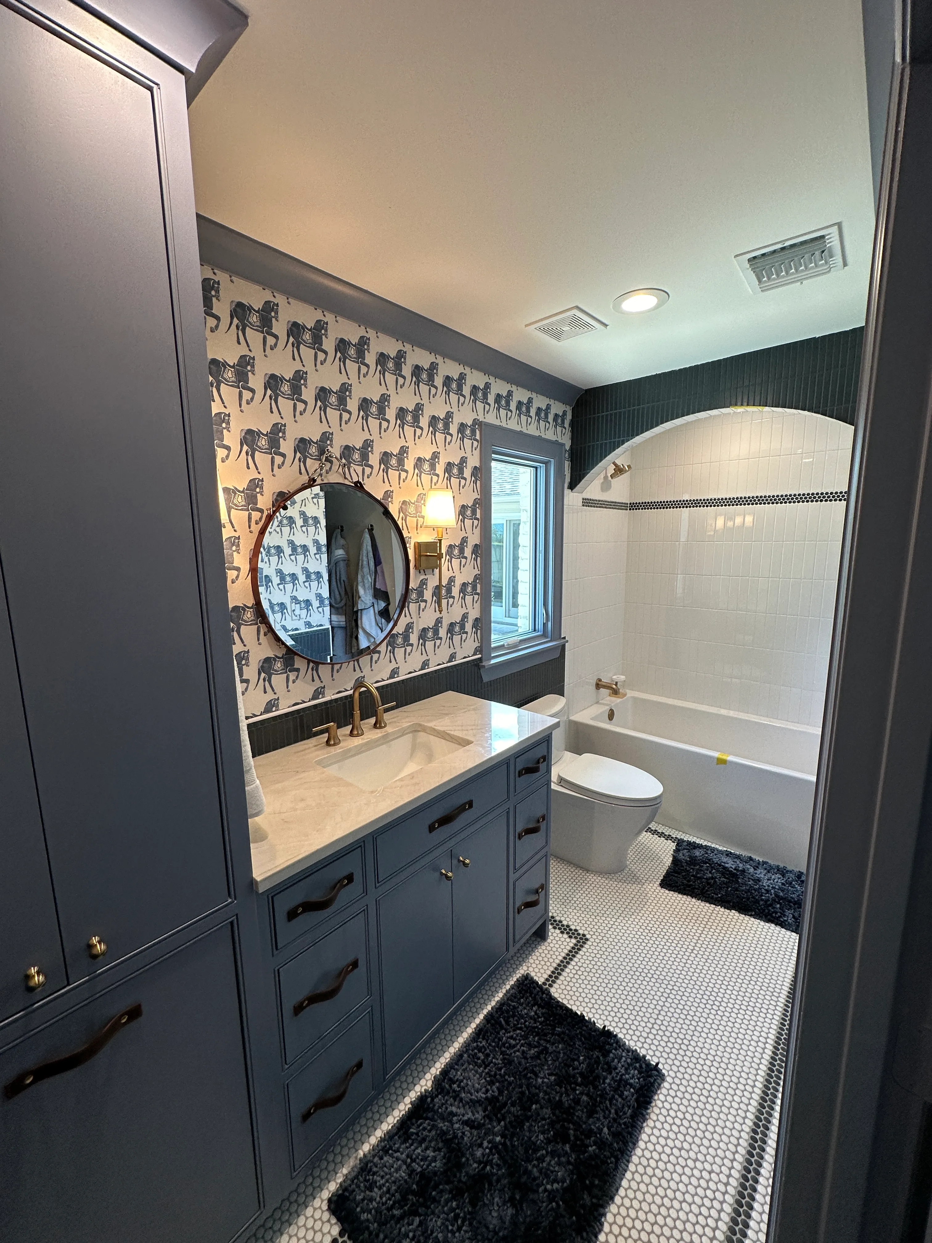 Powder bath with patterned wallpaper and navy vanity