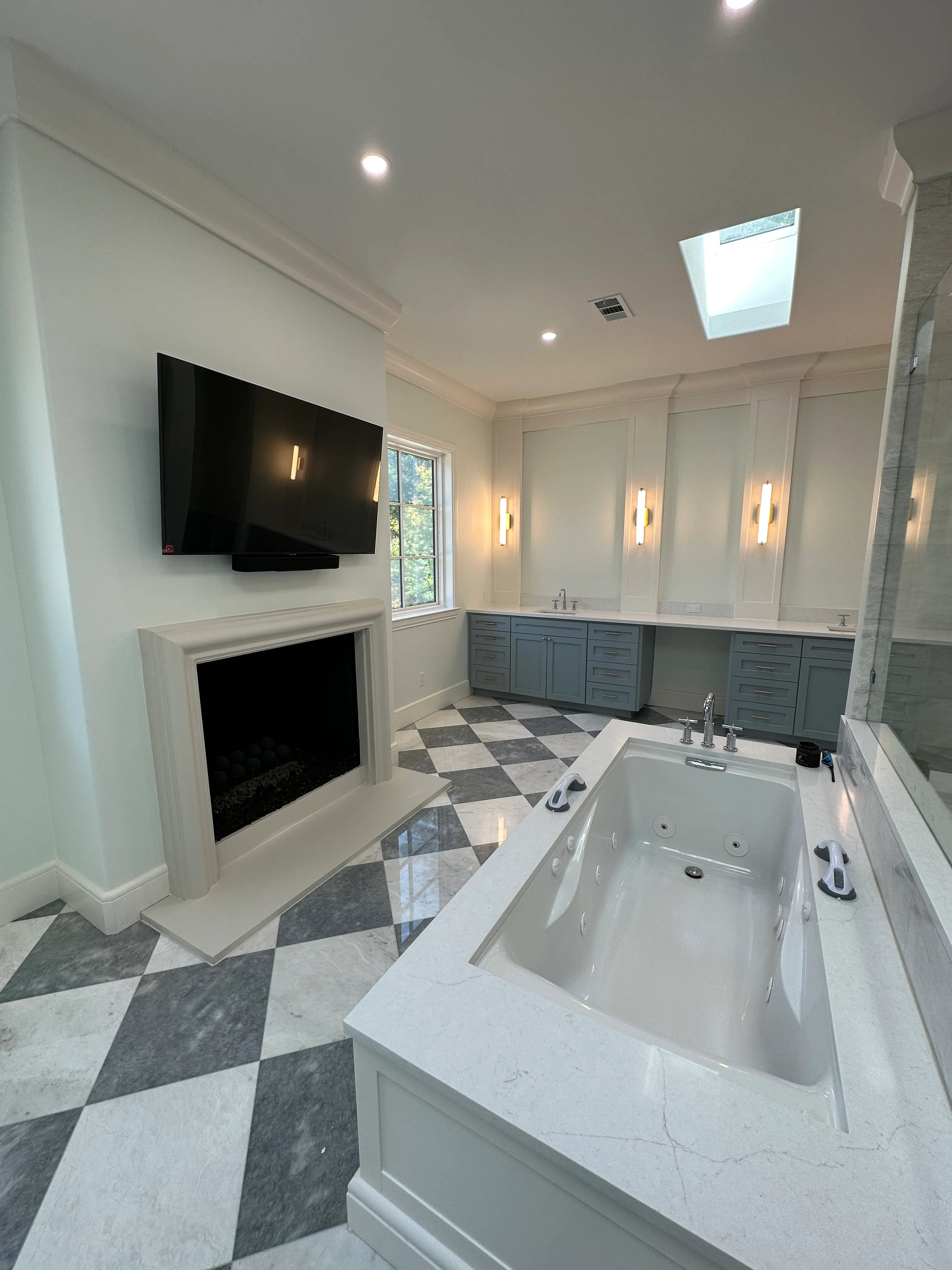 Primary bath with soaking tub and checkerboard marble floor