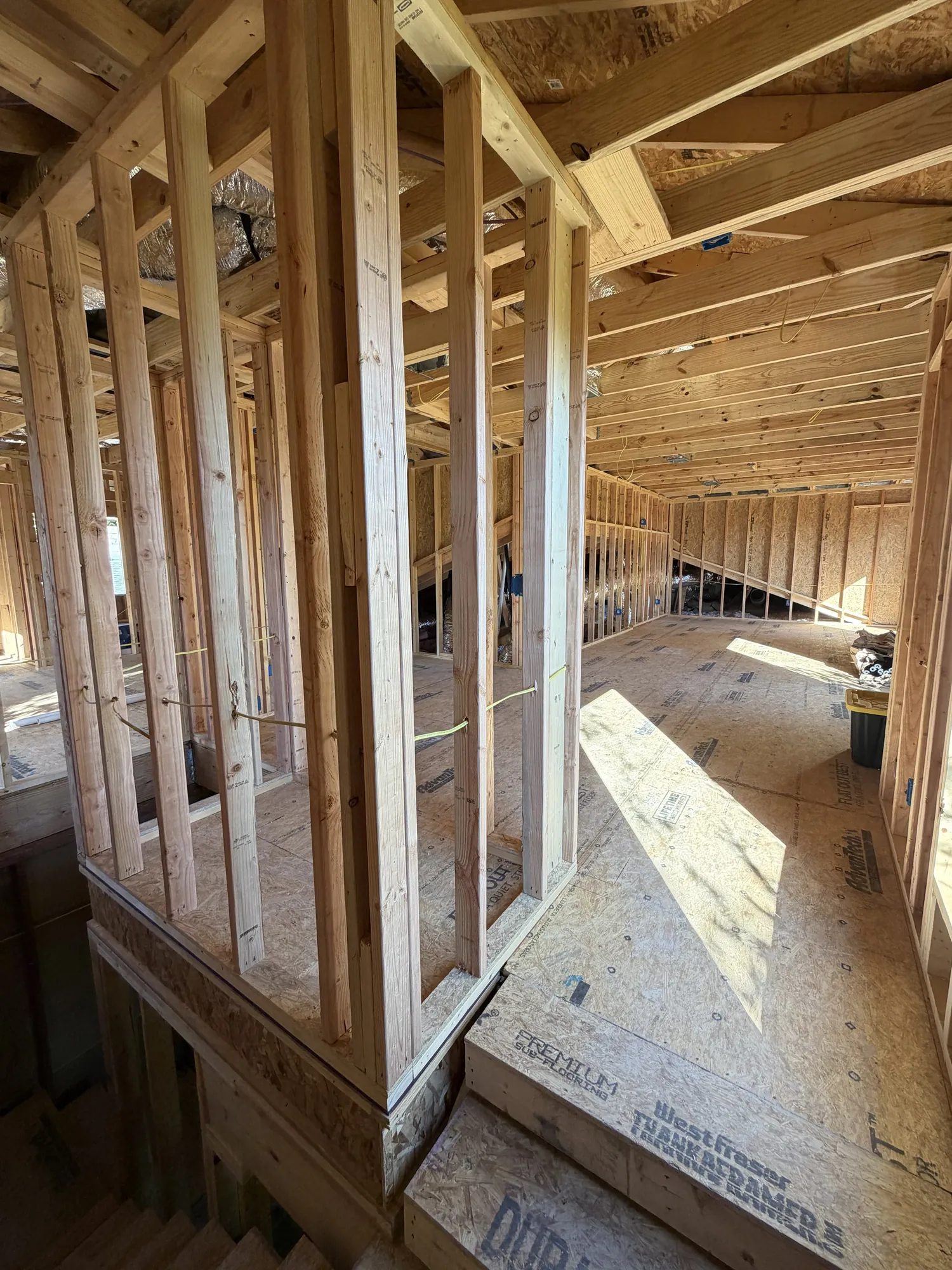 Second-floor framing with HVAC ductwork visible overhead and sheathed subfloor