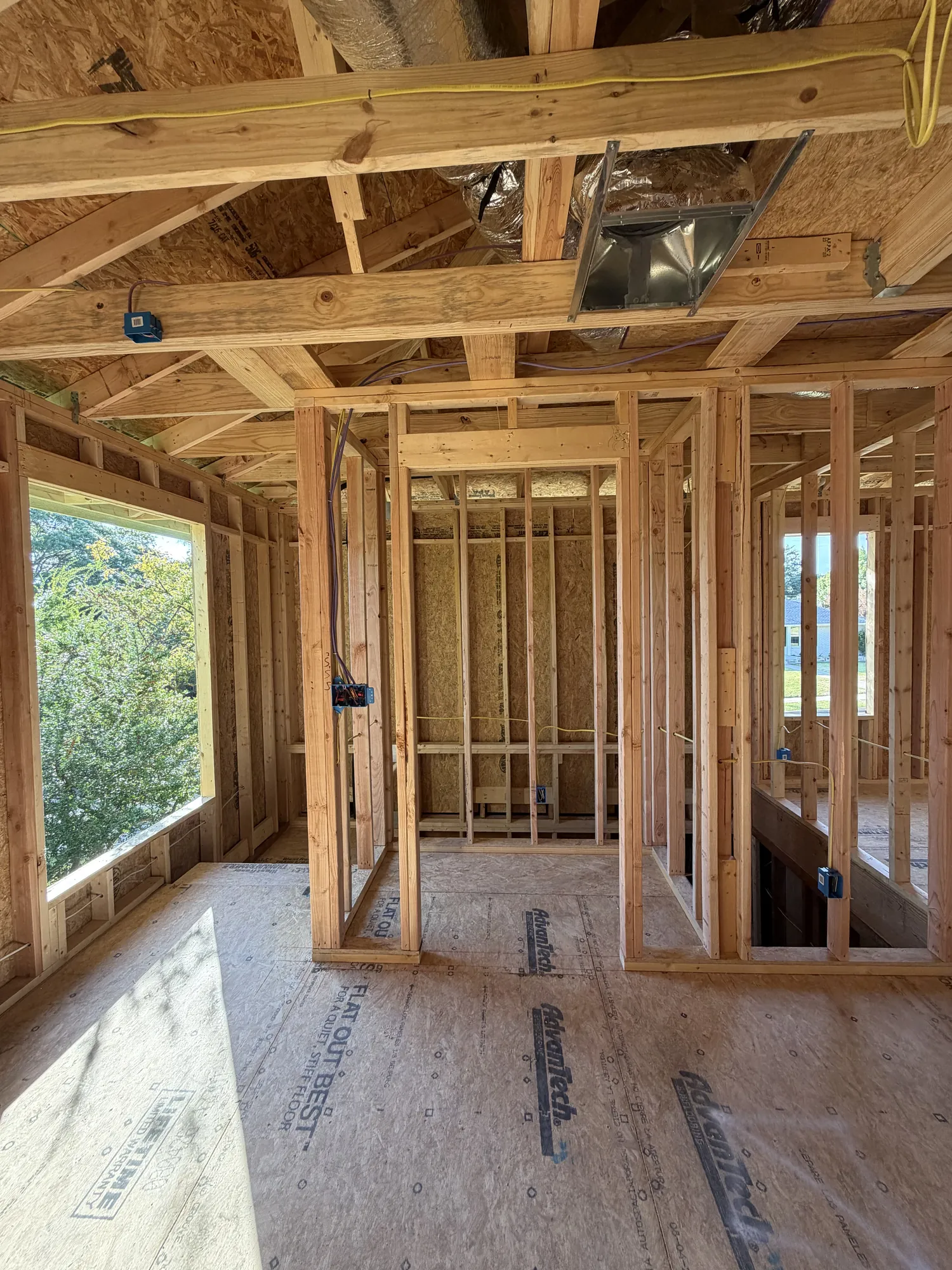 Framed second-floor bathroom area with stairwell opening, window and ductwork overhead
