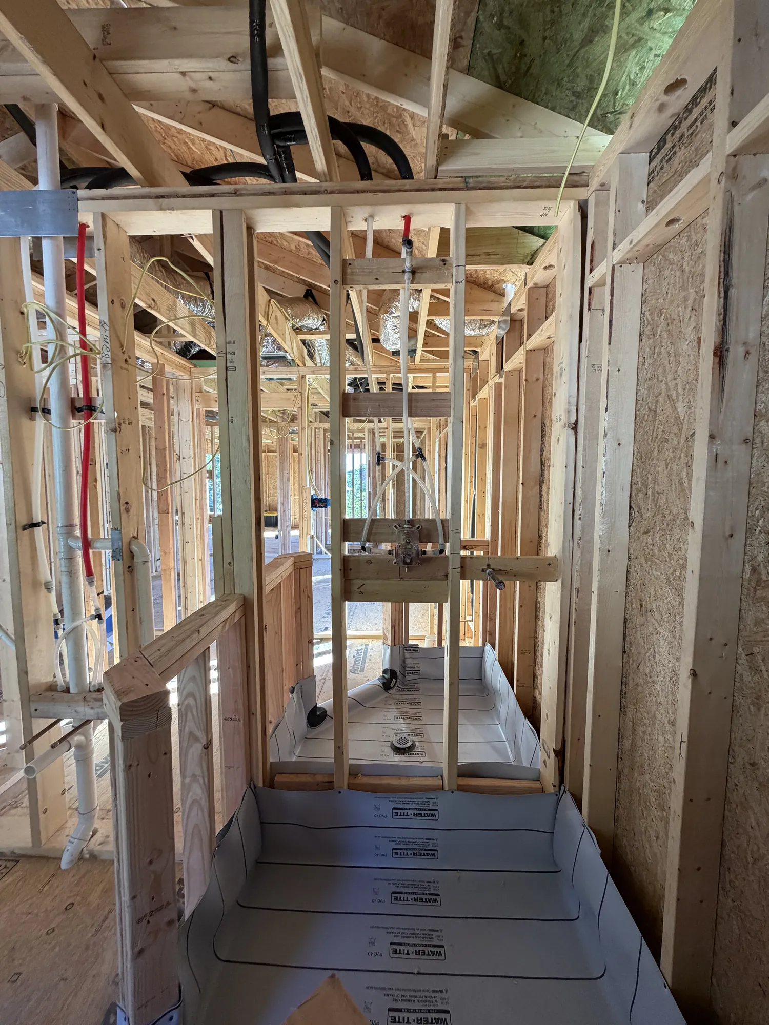 Framed shower with waterproof pan liner and valve rough-in
