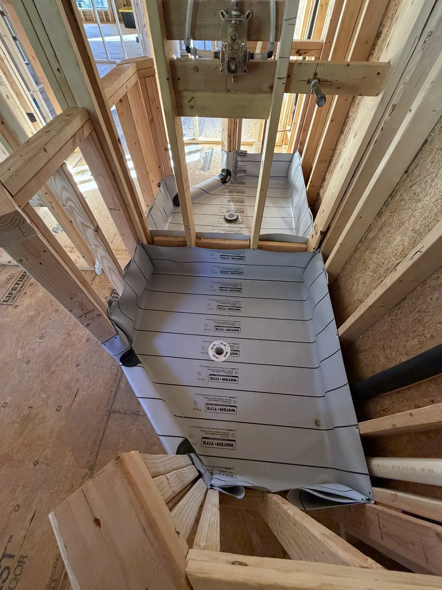 Shower pan waterproof liner installed in a framed shower with drain