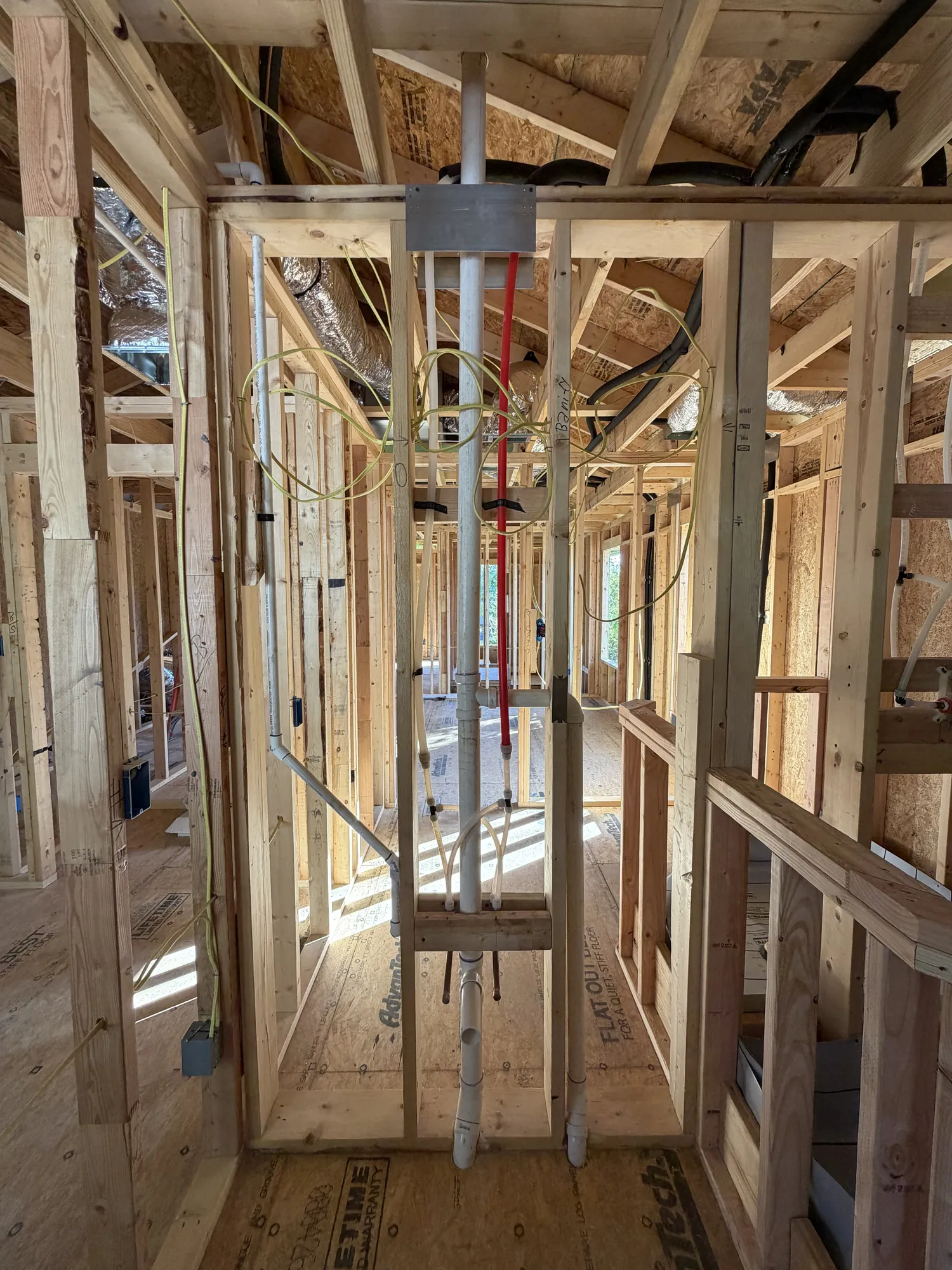 Second-floor wall with electrical conduit, plumbing stack and supply lines roughed in