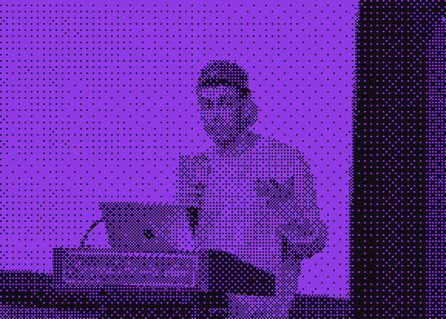 Speaker wearing a cap standing at a podium with a laptop in front during a presentation.