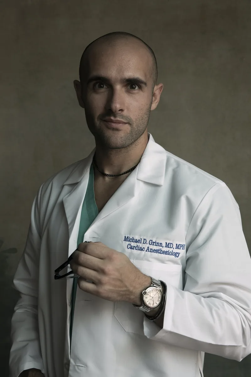 Dr. Michael Grinn, cardiothoracic anesthesiologist, in a white coat over scrubs