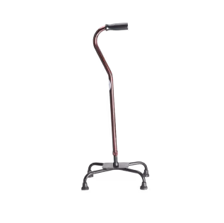 Brown quad cane with black handle and four rubber-tipped legs for support.