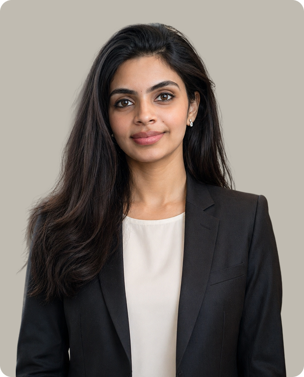 Portrait of a confident woman with long dark hair wearing a black blazer and white blouse against a plain background.