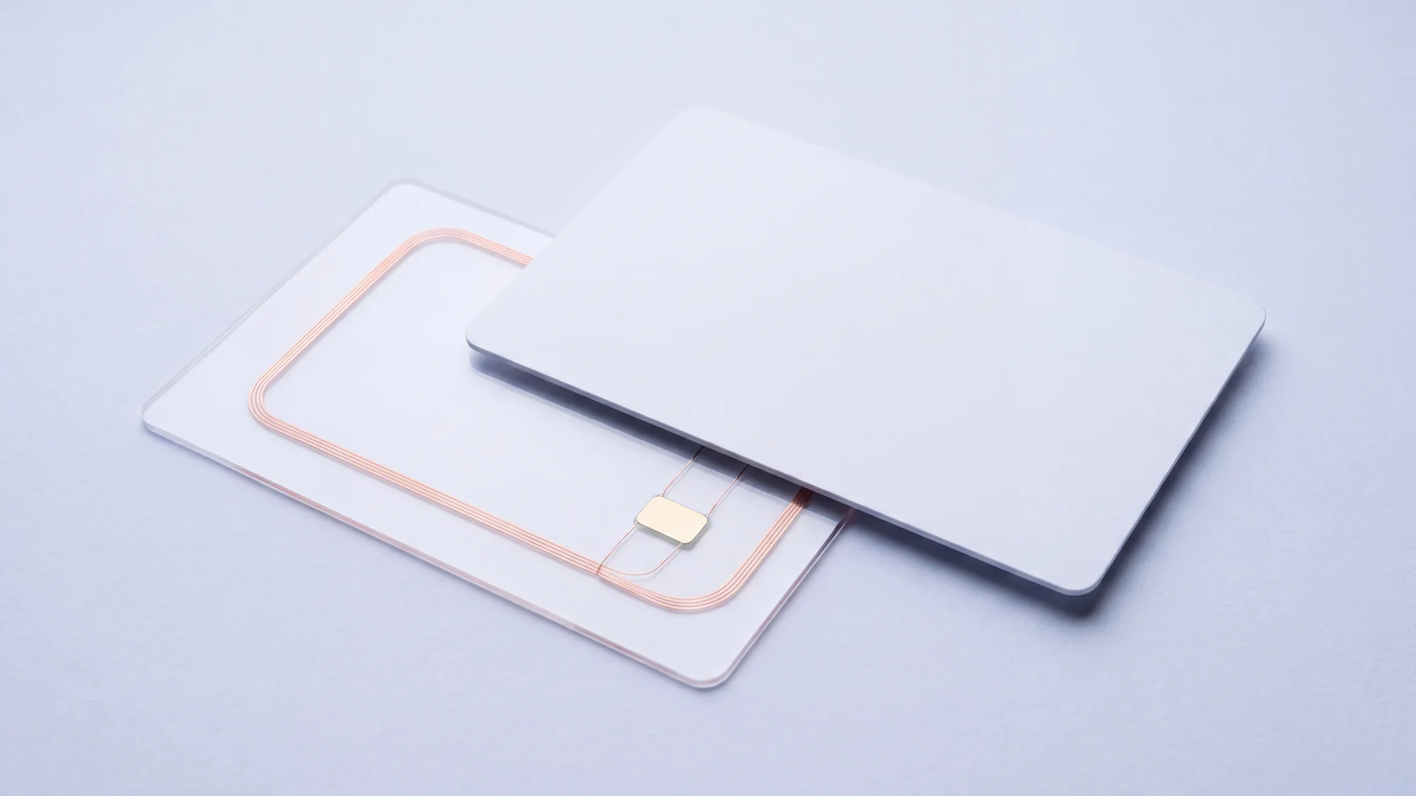 An RFID card in exploded view, its layers separated to reveal the copper antenna loop and the chip inside