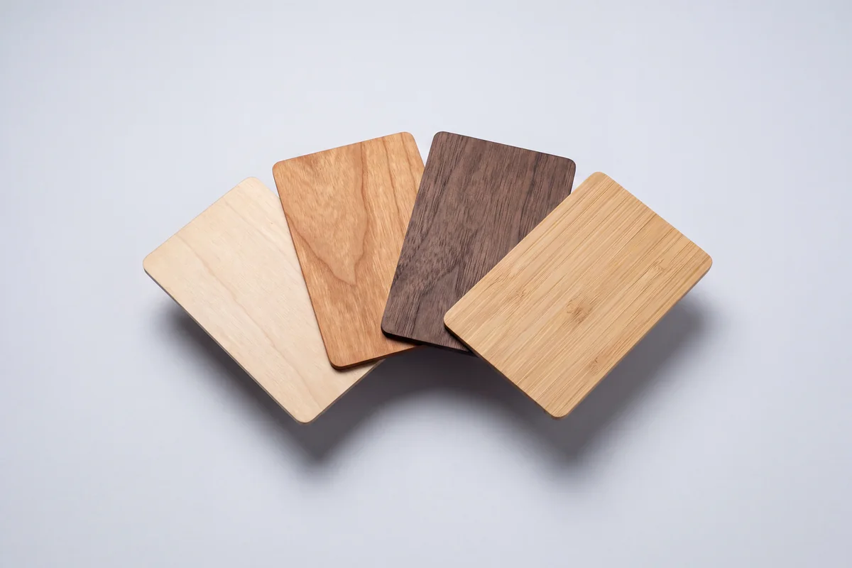 Four blank cards fanned out in basswood, cherry, black walnut and bamboo.