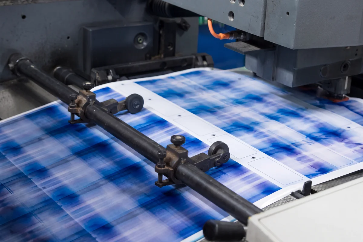 A printed sheet of blank cards running through the offset press in the plant.