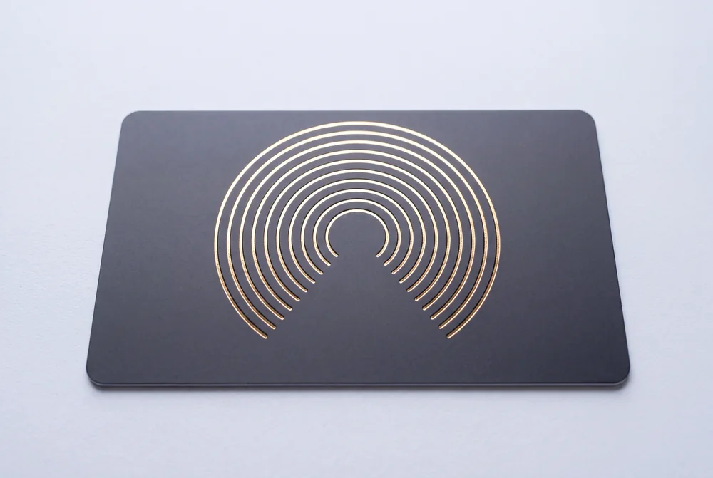 Black card with concentric arcs hot stamped in gold foil