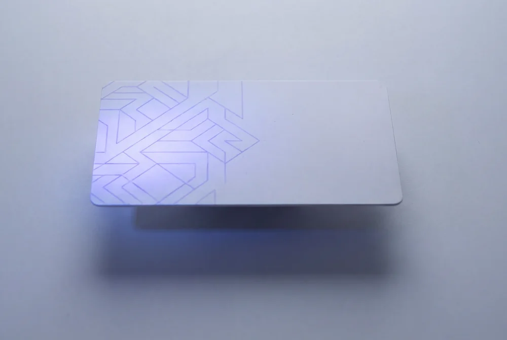 White card under ultraviolet light revealing a hidden printed pattern