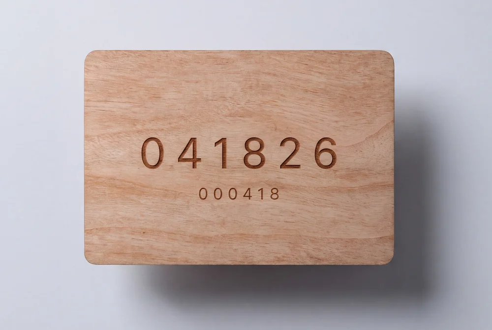 Wooden card with a number laser engraved into the surface, the grain visible through the burnt characters