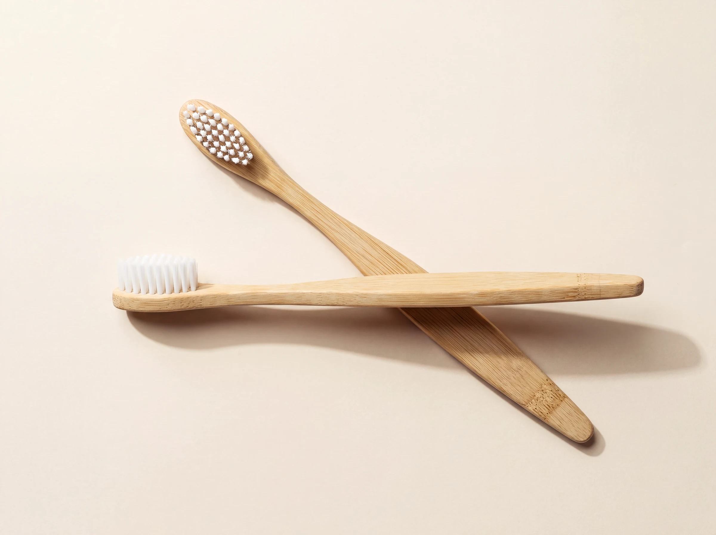 Two bamboo toothbrushes crossed at the handle