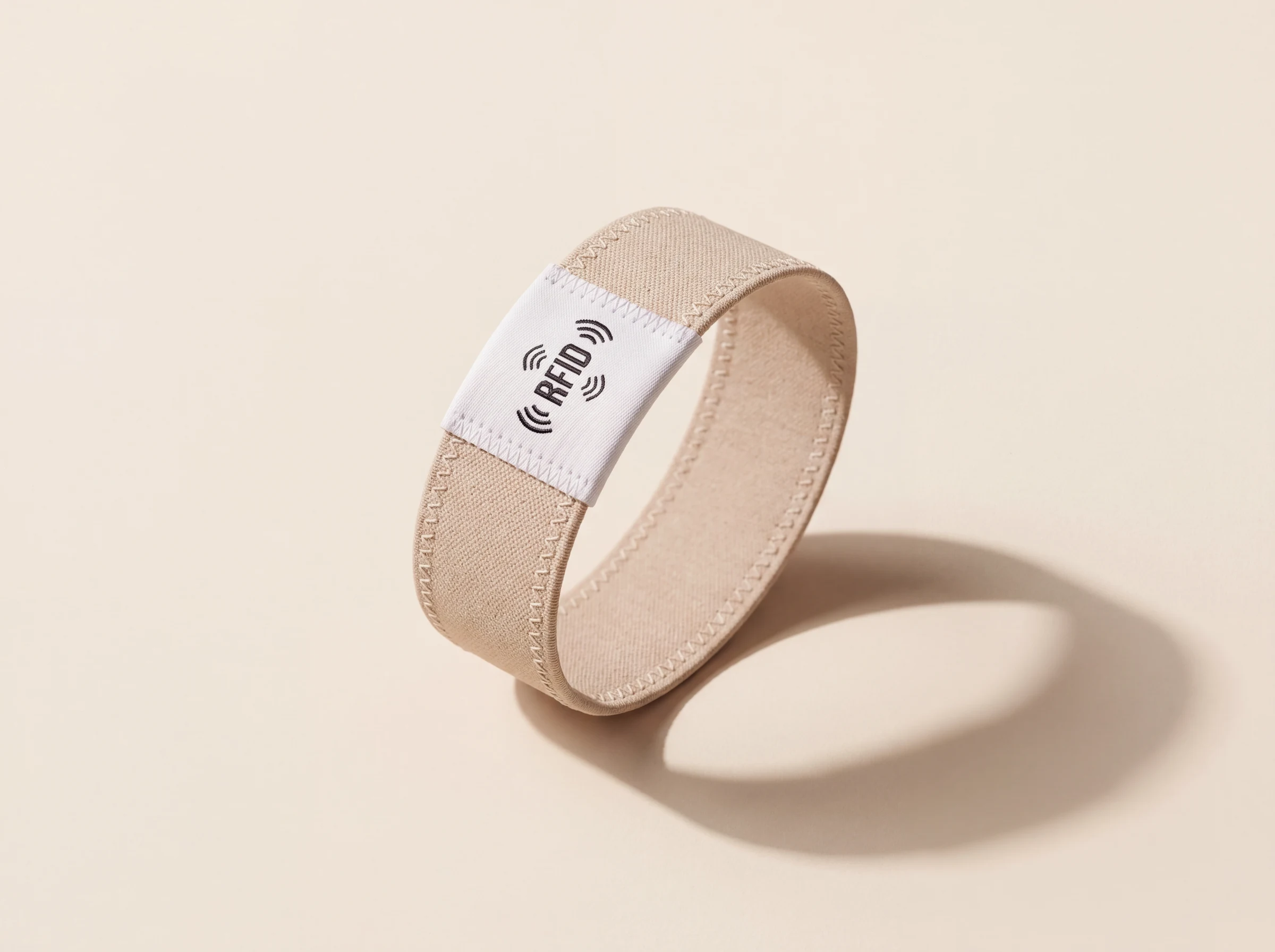 Stretch fabric RFID wristband in sand, with the chip in the woven label