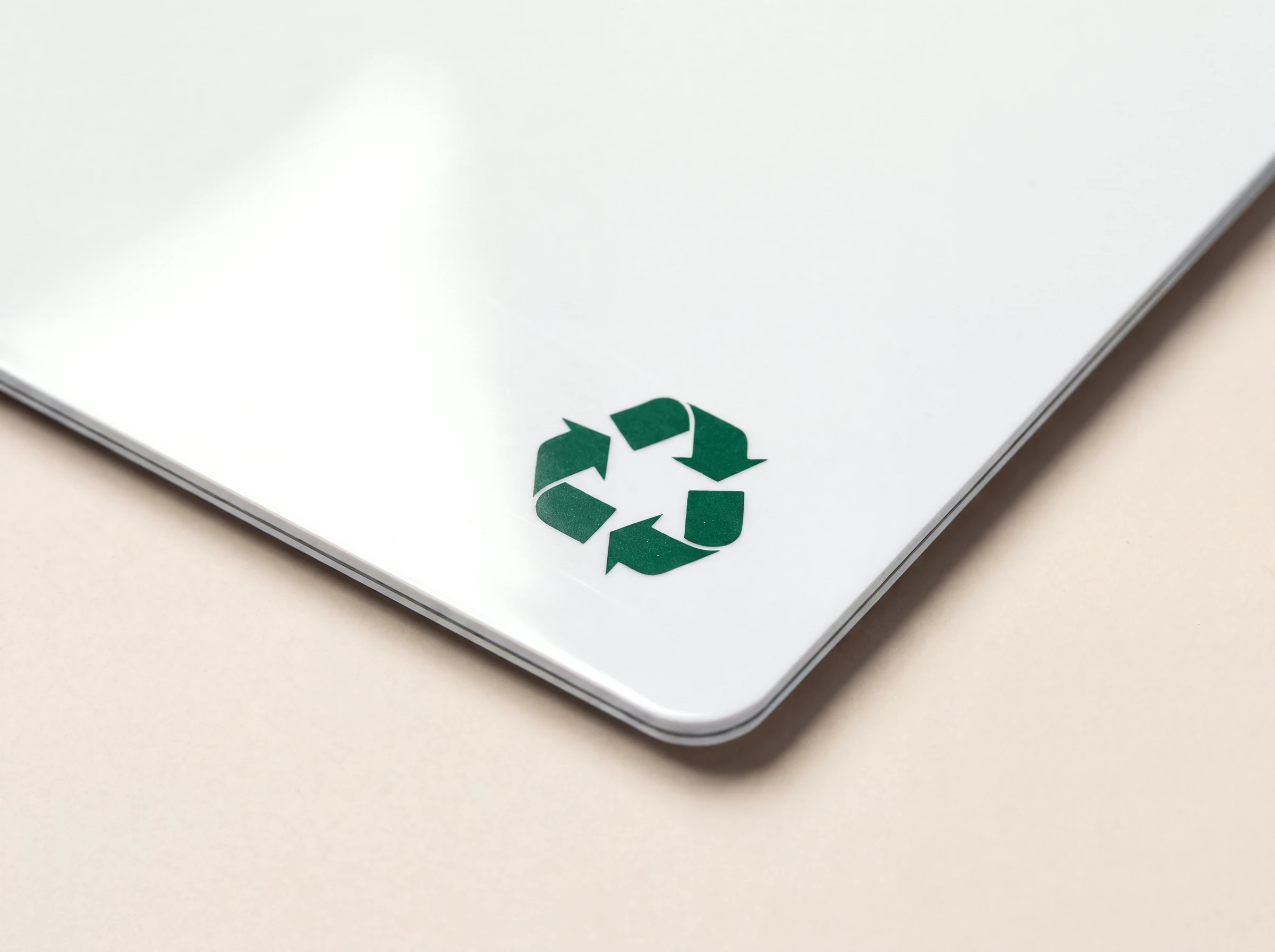 Close up of the corner of a recycled PVC card, printed with a green recycling symbol