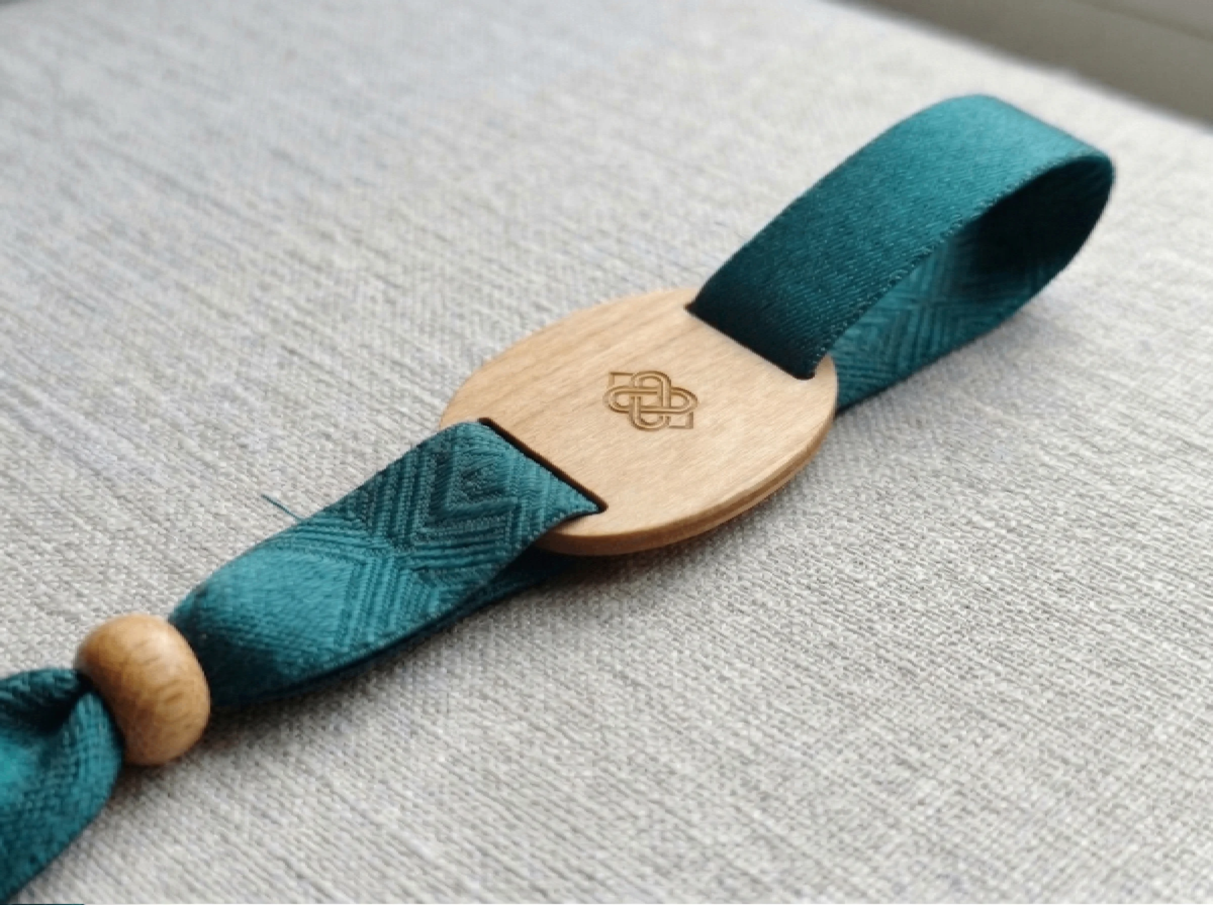 Woven fabric wristband with an engraved wooden plate and a wooden bead closure
