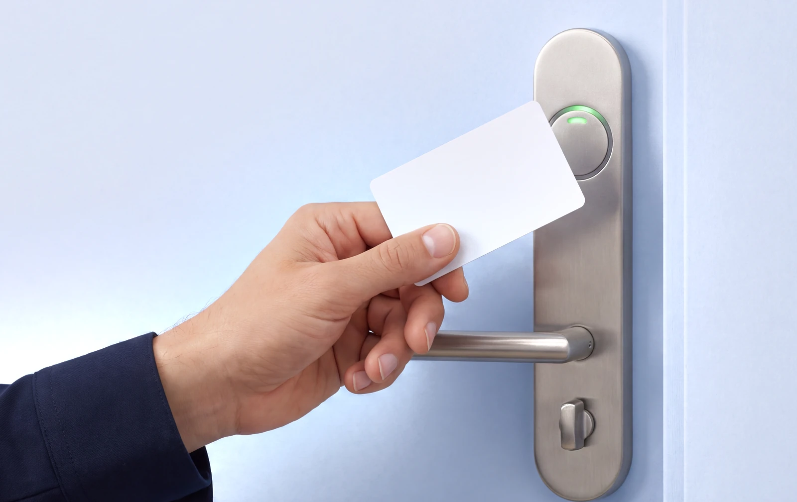 A blank white PVC card resting across the corner of a square white access reader