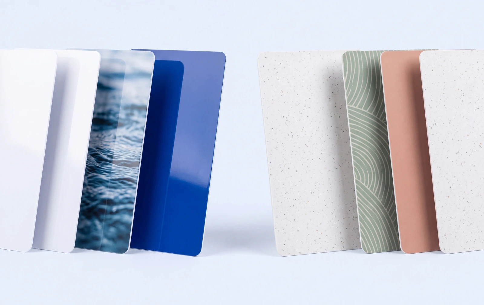 Gloss white PVC cards beside matte recycled PVC cards, the recycled ones speckled through the material