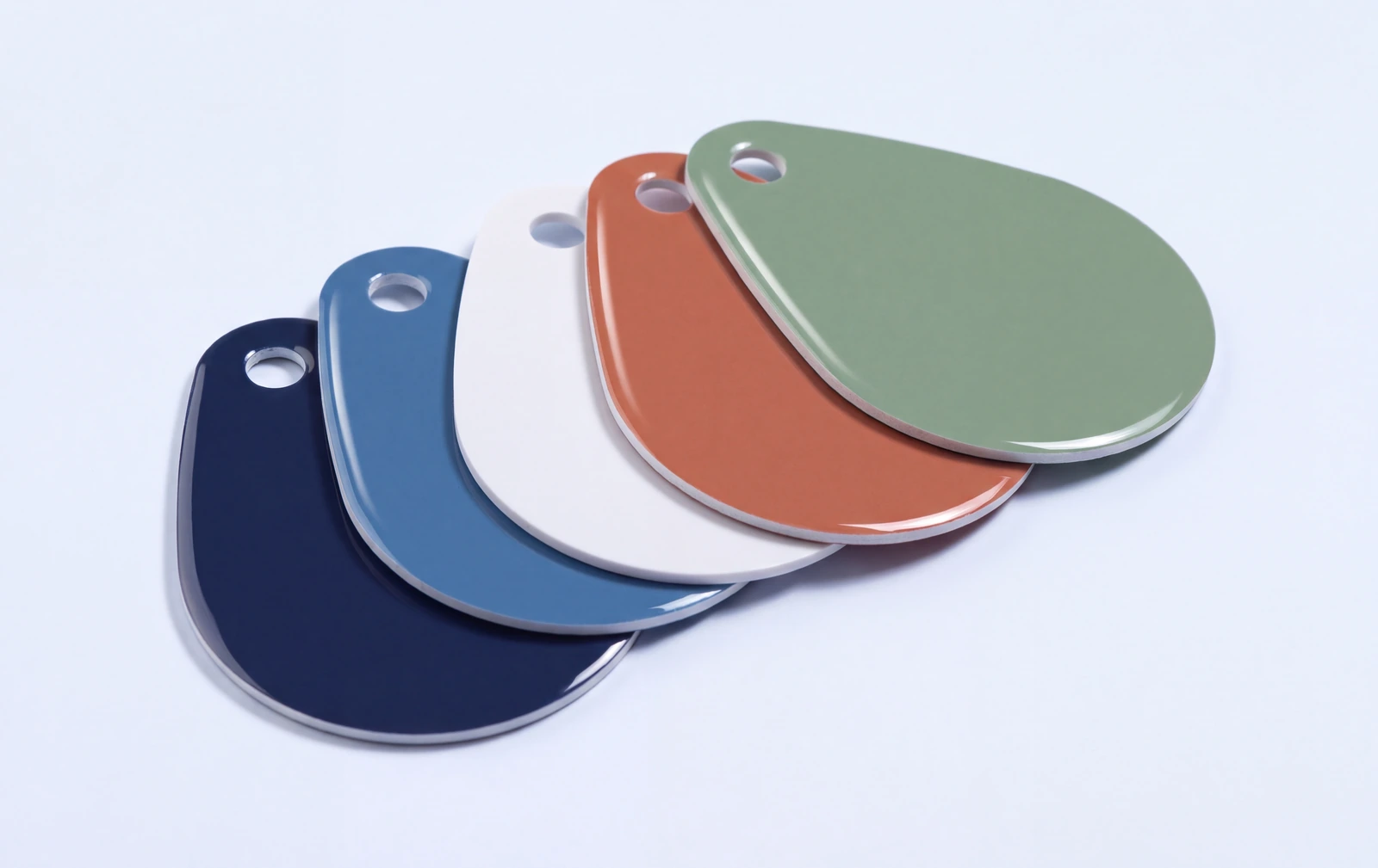 Five gloss laminated PVC key tags in a teardrop shape, fanned out in navy, blue, white, terracotta and sage, each with a punched hole