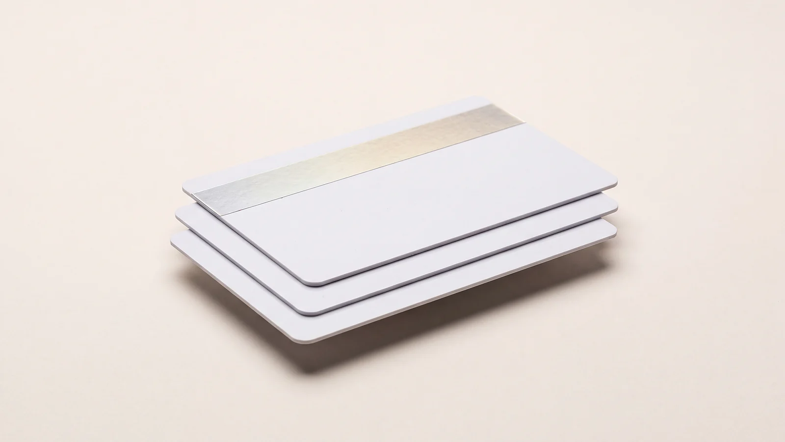 Three cards stacked in a stagger, the top one with a silver holographic strip