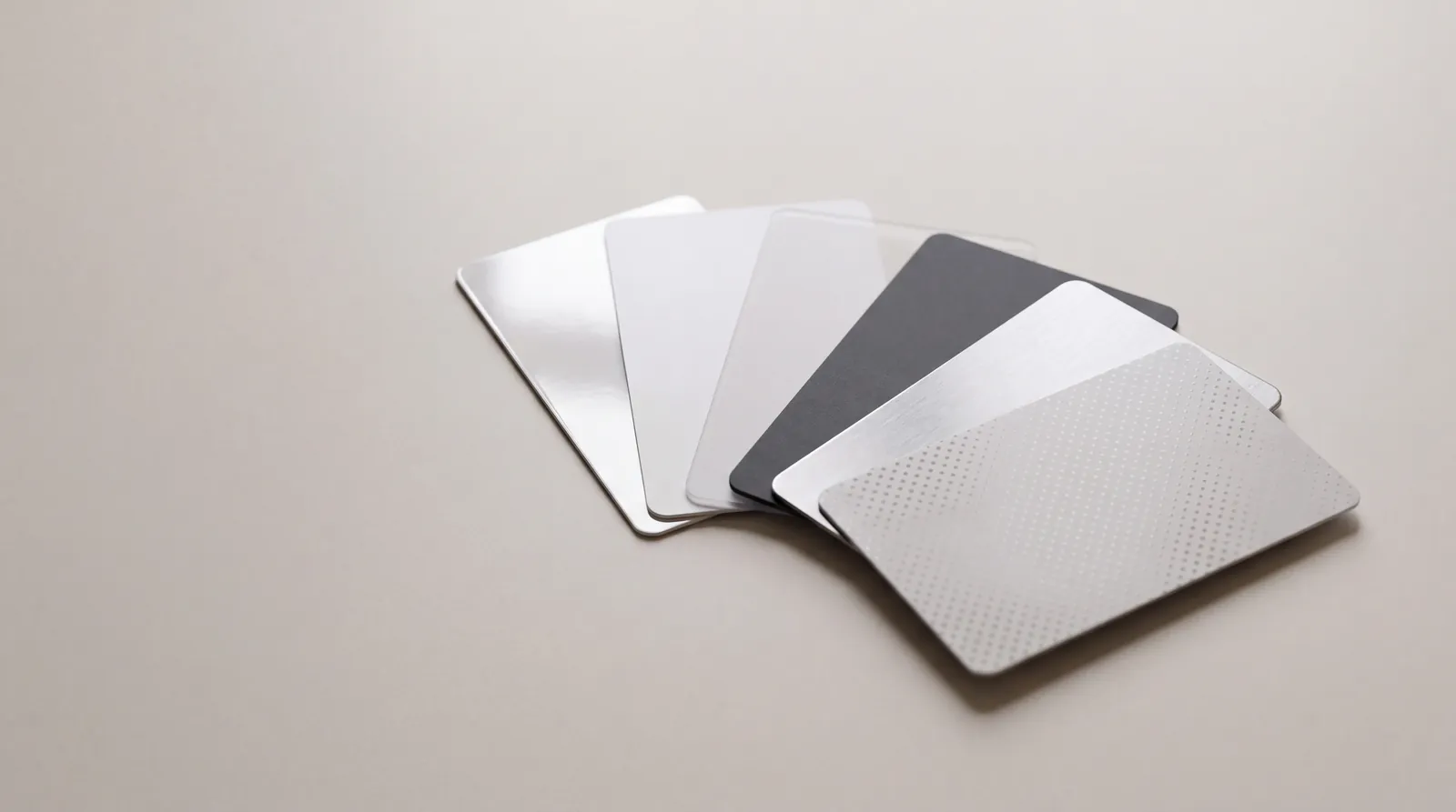 Six cards fanned out showing gloss, matte, frosted, soft touch and metallic finishes