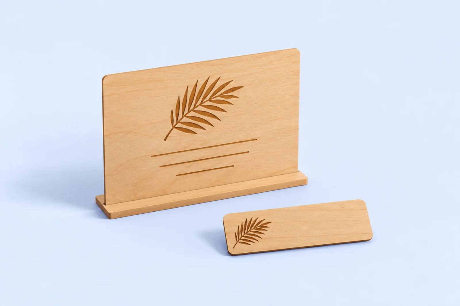 Slim wooden table sign on a low base with a laser engraved palm leaf, next to a thin wooden staff name badge with a small engraved palm leaf