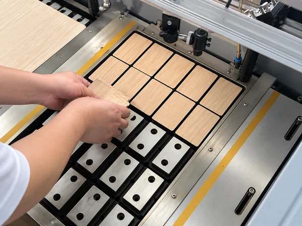 Wooden card blanks lifted from the laser cutting bed