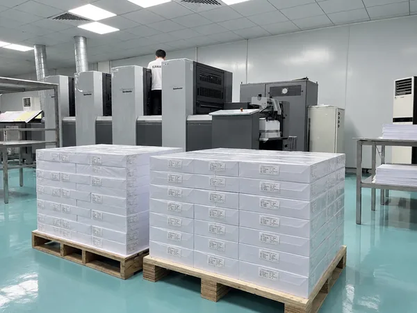 Pallets of printed card sheets beside the offset presses