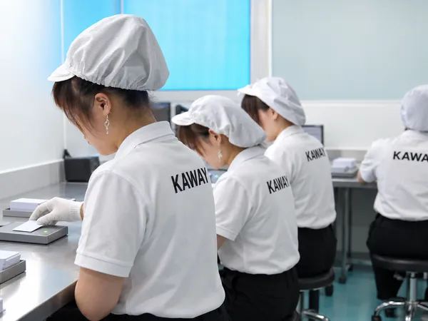 Operators read-testing encoded cards one by one at the plant in Dongguan