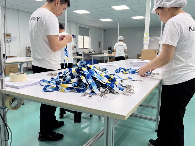 Team finishing printed blue and yellow lanyards with metal hooks on a packing table
