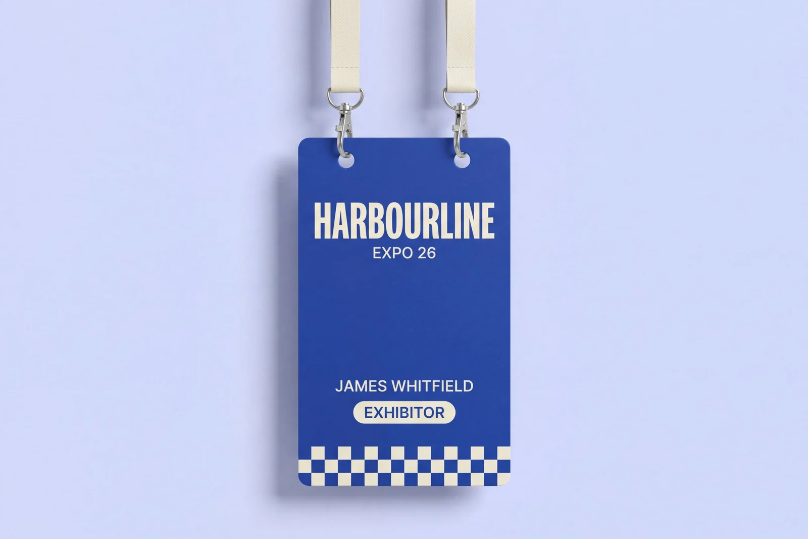 Large RFID conference badge in cobalt blue with an ivory checkerboard band, hanging from two lanyard holes on an ivory double lanyard