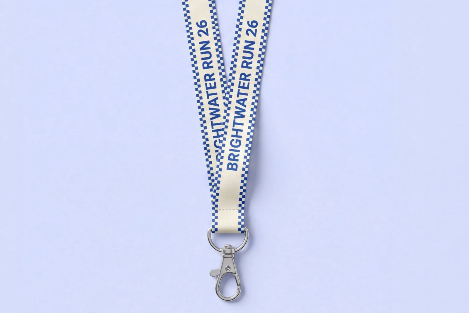 Ivory flat polyester lanyard printed with a repeating event name in cobalt blue and checkerboard edges, with a swivel hook