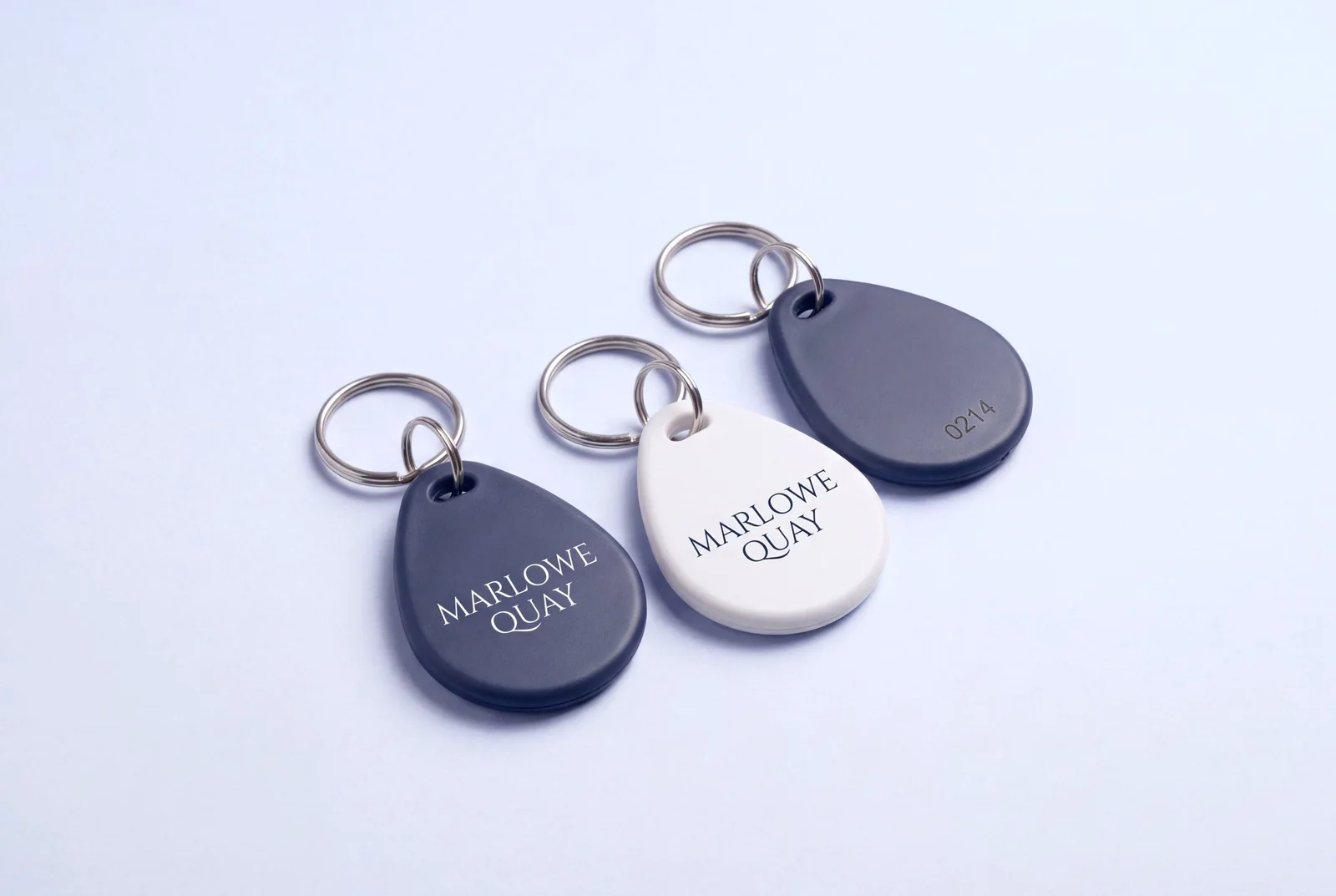 Three teardrop RFID key fobs in moulded ABS, two navy and one white, printed with a fictional hotel name