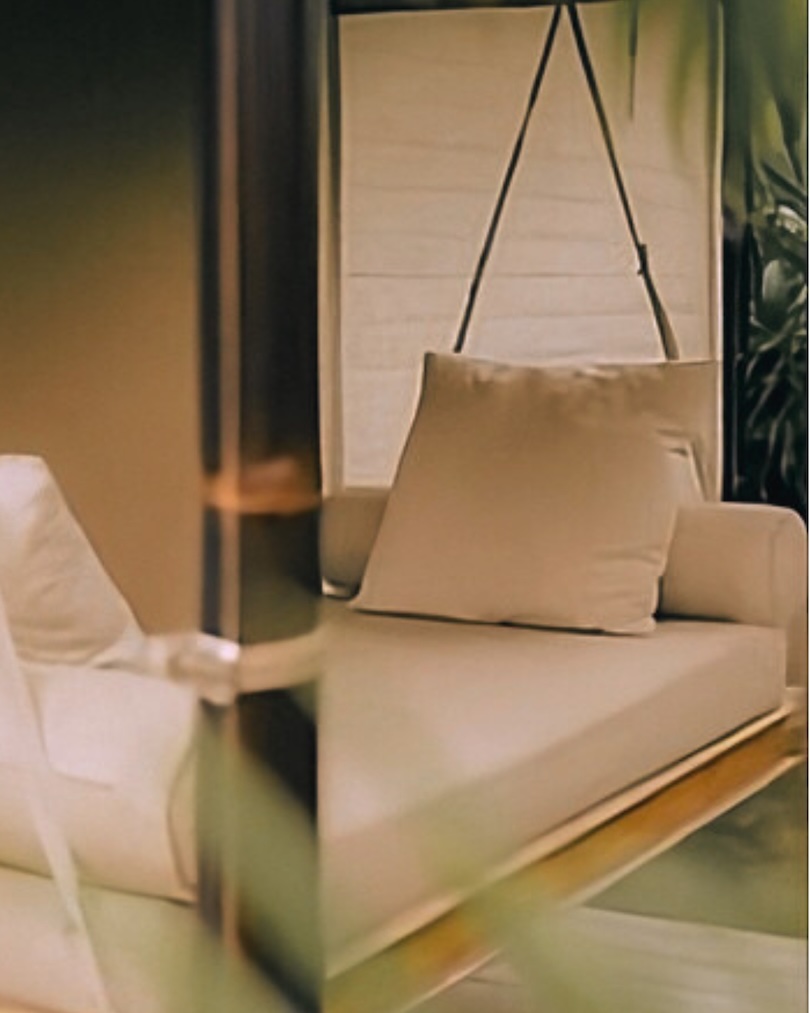 Beige cushioned hanging chair with pillow in a softly lit indoor space.