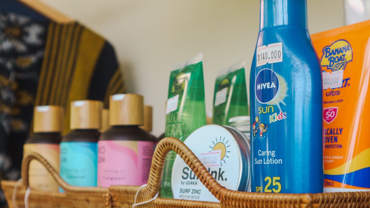 Basket with assorted skincare and sun protection products including NIVEA Sun Kids lotion and Banana Boat sunscreen.