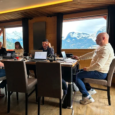 Session de travail de l’équipe Hive dans un chalet avec vue sur les Alpes