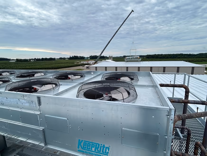 Unités de climatisation industrielles sur toit avec grue et paysage rural