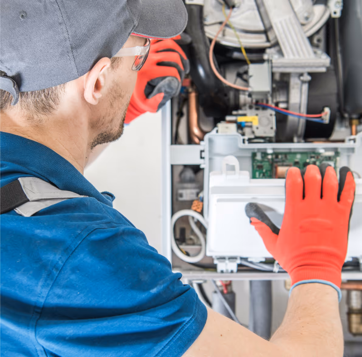 Technicien en gants rouges réparant les composants électroniques internes d'un appareil.