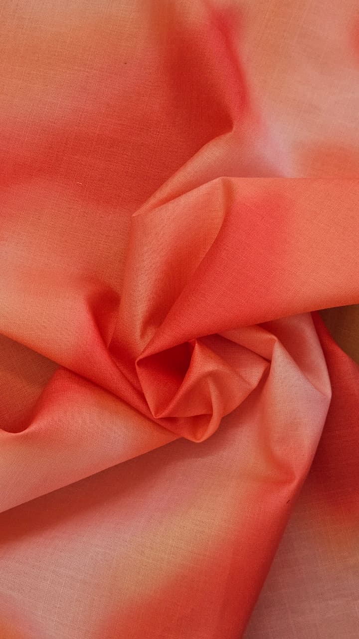 Close-up of soft, wrinkled pink cotton fabric displaying fine weave texture.