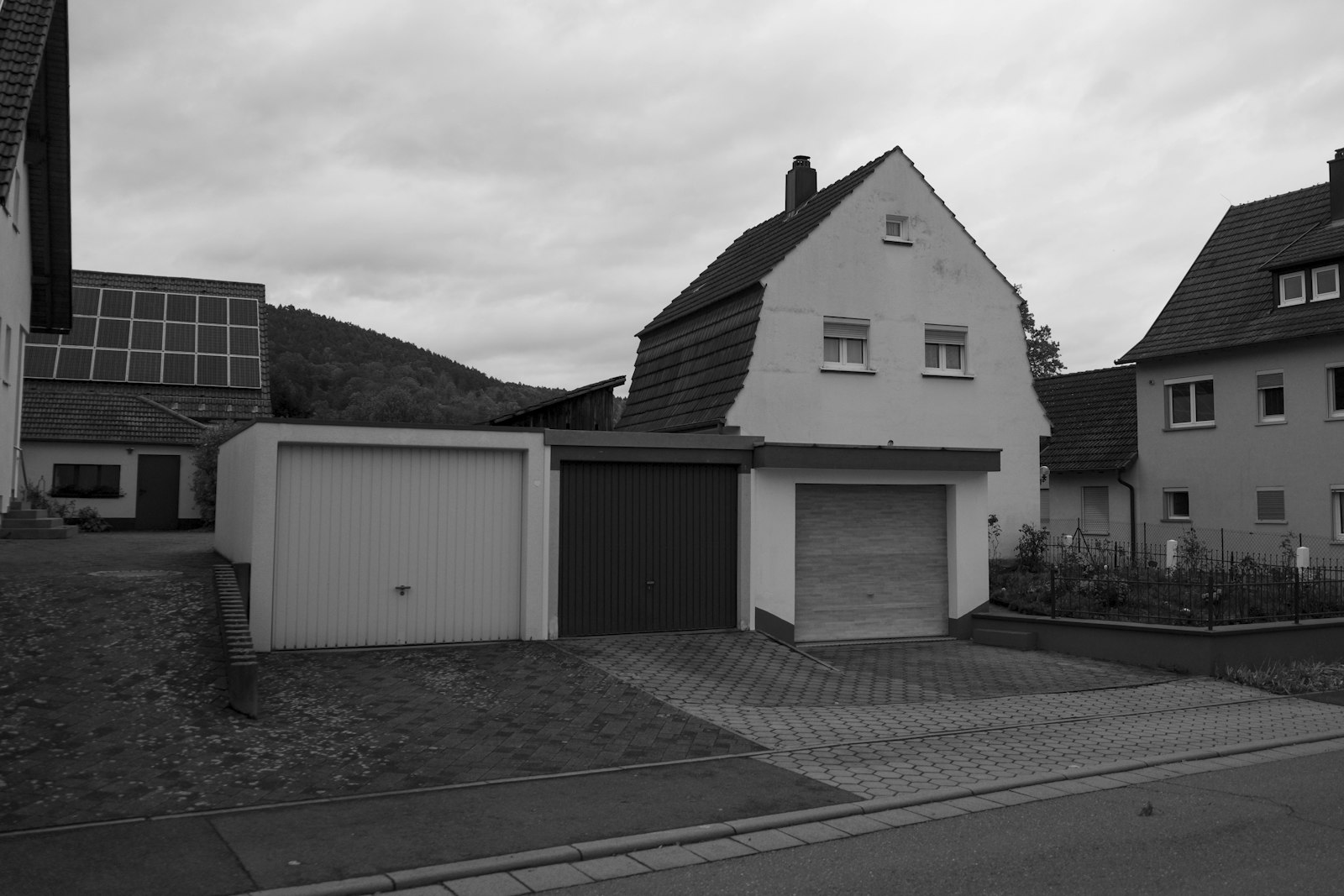 Neu gebautes Einfamilienhaus mit Doppelgarage und Solarmodulen auf dem Dach in einem Neubaugebiet