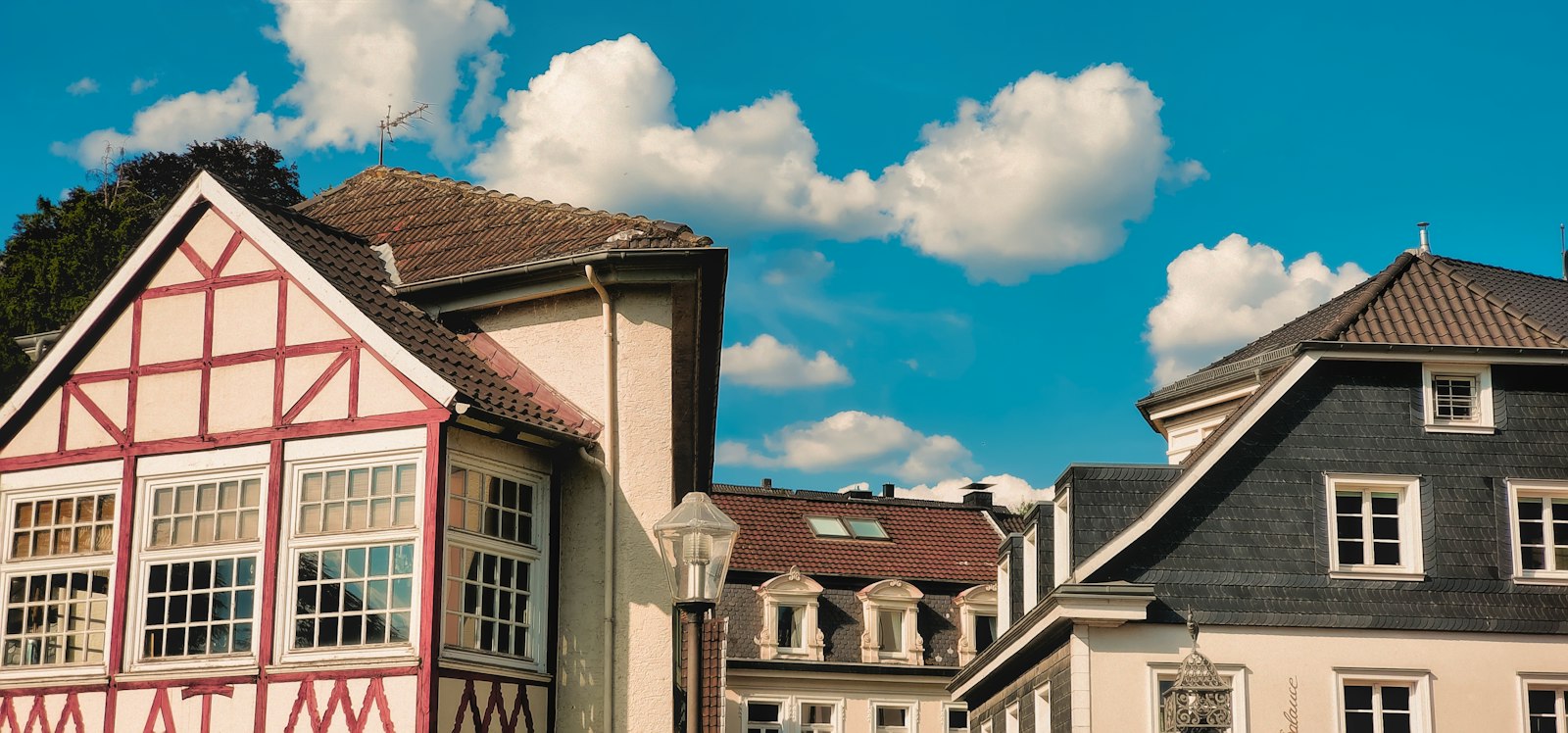Fachwerkhaus und schiefergedeckte Altbauten in Essen-Kettwig unter blauem Himmel mit Wolken