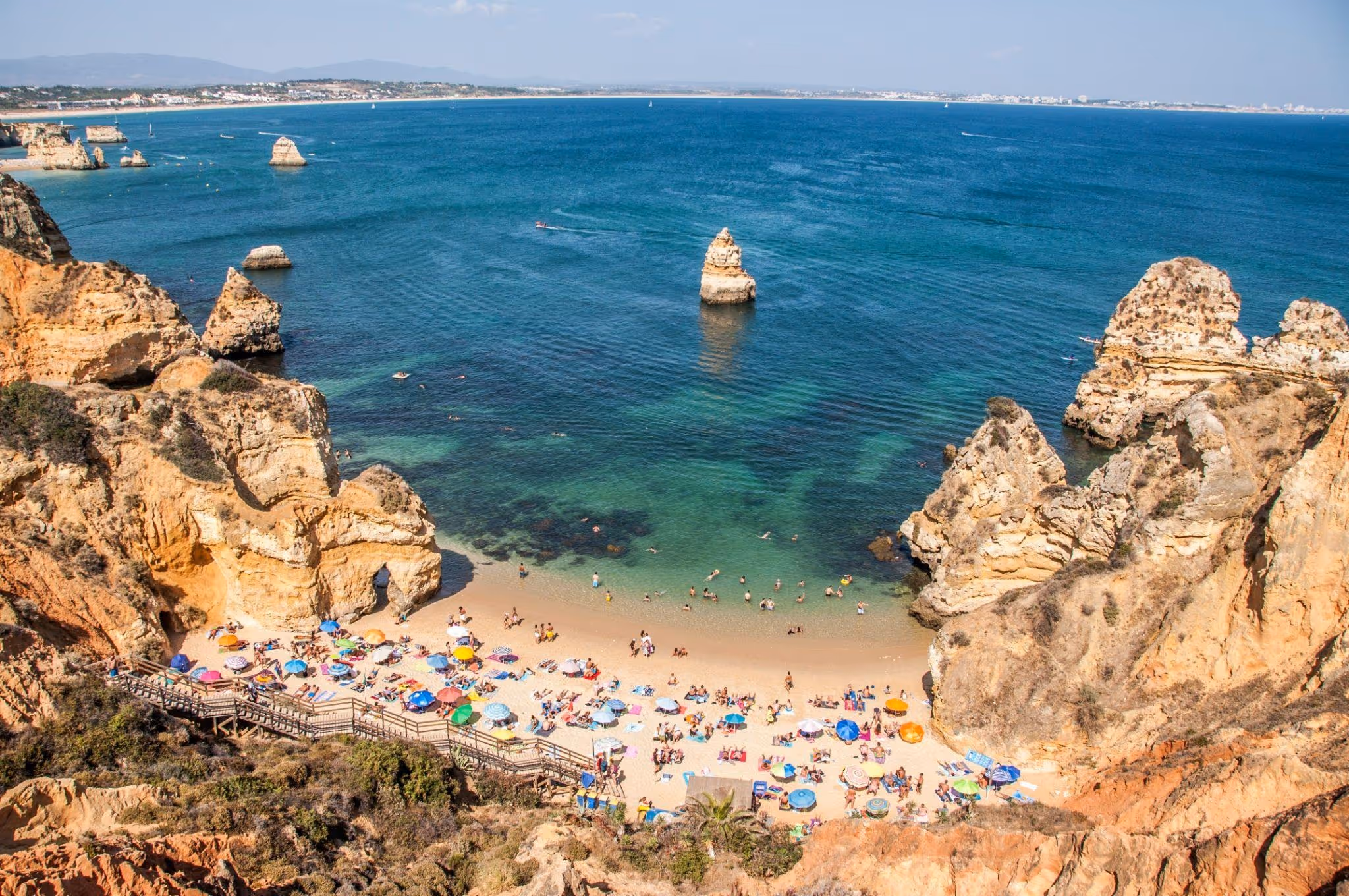 source: https://unsplash.com/photos/a-group-of-people-on-a-beach-near-the-ocean-D4Zg_w206Ws