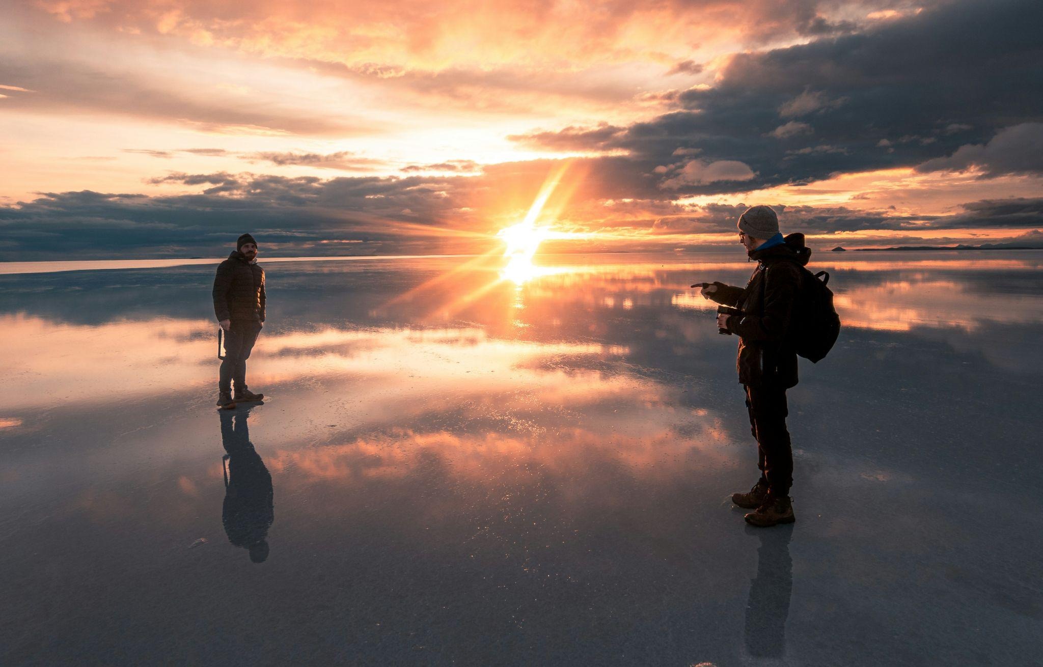 source: https://unsplash.com/photos/a-couple-of-people-that-are-standing-in-the-sand-AjrwMrCgjMs