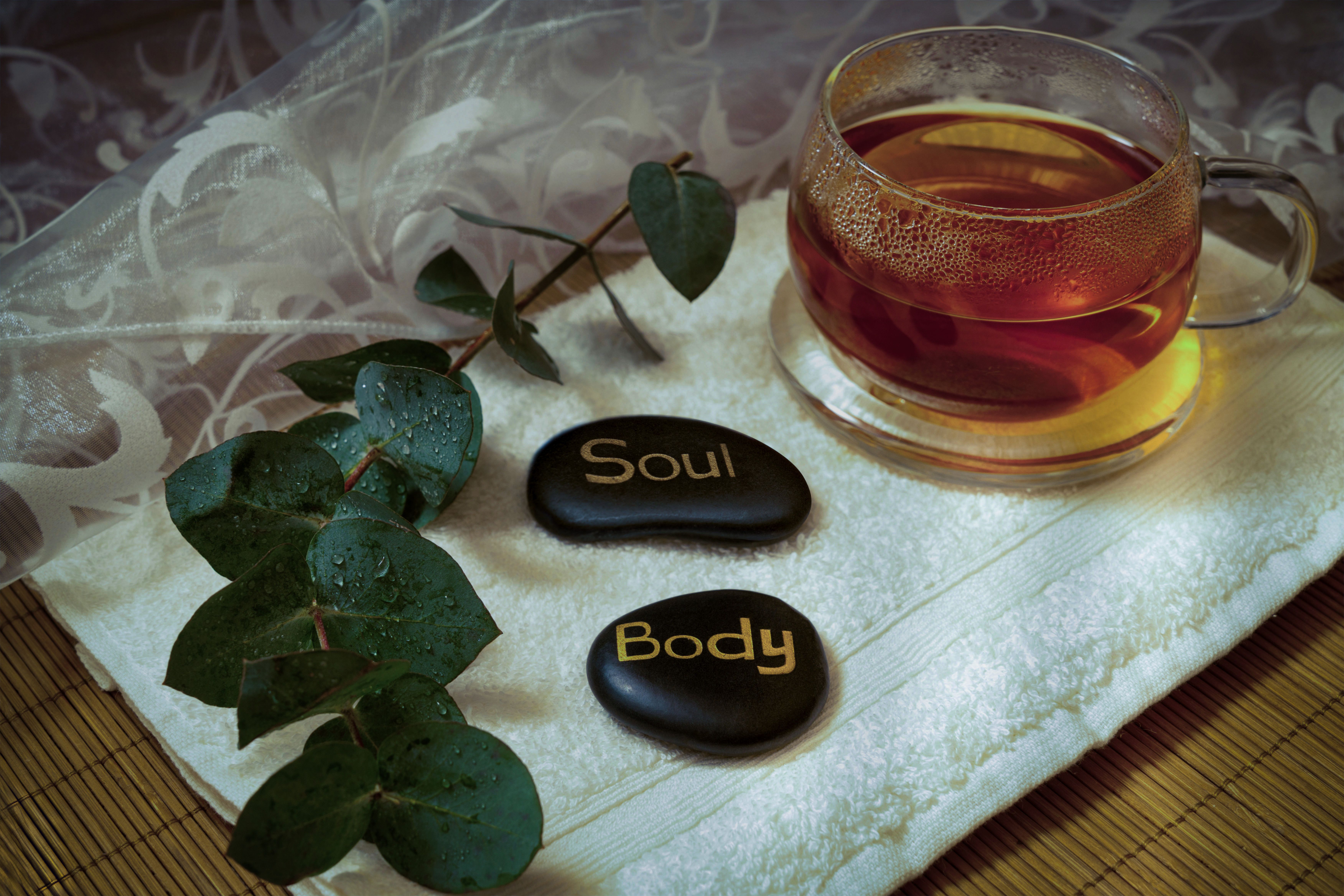 Calming spa setting with herbal tea and engraved wellness stones